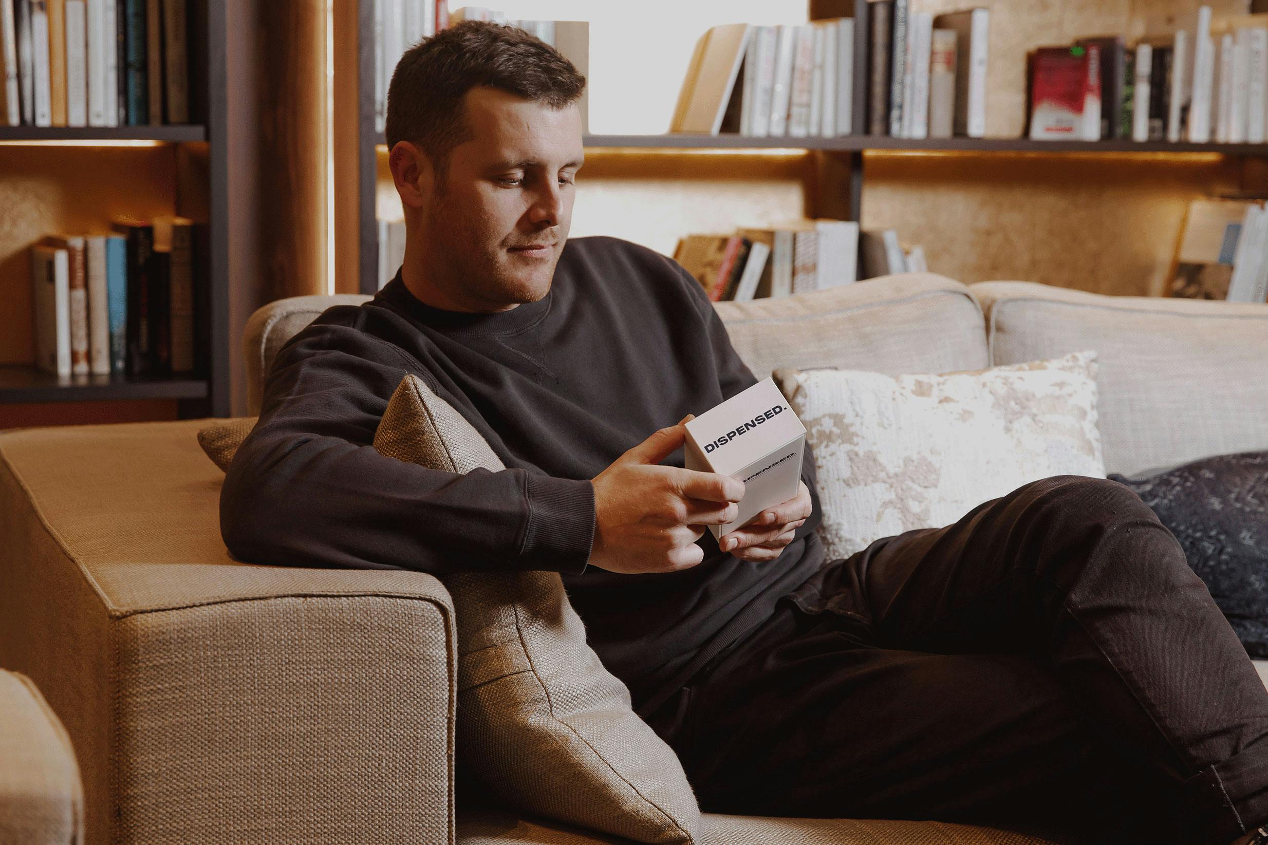 A person on a couch with a white box